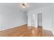 Open bedroom with hardwood floors, a ceiling fan, and access to a bathroom and closet at 5070 Riverlake Dr, Peachtree Corners, GA 30097