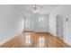 A bedroom with hardwood floors and bright windows with views of outdoors at 5070 Riverlake Dr, Peachtree Corners, GA 30097