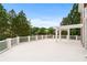 Expansive outdoor deck with white railings and a pergola overlooking a scenic lake view at 5070 Riverlake Dr, Peachtree Corners, GA 30097