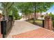 Grand brick home with a long driveway framed by trees and iron gates for added privacy and curb appeal at 5070 Riverlake Dr, Peachtree Corners, GA 30097