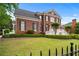 Charming brick home with black shutters, a manicured lawn, and lovely landscaping, creating great curb appeal at 5070 Riverlake Dr, Peachtree Corners, GA 30097