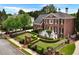 Stately brick home boasts mature landscaping, an iron fence, and a grand stairway to the front door at 5070 Riverlake Dr, Peachtree Corners, GA 30097