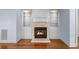 Cozy living room features a fireplace with tiled surround, built-in bookshelves, and hardwood floors at 5070 Riverlake Dr, Peachtree Corners, GA 30097