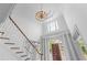 Bright foyer with staircase and elegant chandelier at 5070 Riverlake Dr, Peachtree Corners, GA 30097