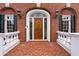 Close-up of the home's entrance, showing a beautiful wood door with decorative glass and classic brick architecture at 5070 Riverlake Dr, Peachtree Corners, GA 30097