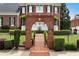 Charming brick home with manicured lawn and trimmed hedges, and an arched entrance creating a warm and inviting feel at 5070 Riverlake Dr, Peachtree Corners, GA 30097