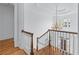 Second floor hallway shows wood banister, staircase, chandelier, and stained glass at 5070 Riverlake Dr, Peachtree Corners, GA 30097