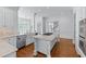 Spacious white kitchen with a center island, stainless appliances, and hardwood floors at 5070 Riverlake Dr, Peachtree Corners, GA 30097