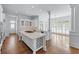 Open kitchen with an island, stainless appliances, hardwood floors, and bright natural light at 5070 Riverlake Dr, Peachtree Corners, GA 30097