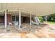 Stone patio with outdoor furniture and manicured backyard at 5070 Riverlake Dr, Peachtree Corners, GA 30097
