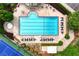 Aerial view of a community pool with a sunbathing deck, a hot tub, and a tennis court at 5070 Riverlake Dr, Peachtree Corners, GA 30097