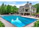 A luxurious community pool with sunbathing chairs and tables, located behind a building at 5070 Riverlake Dr, Peachtree Corners, GA 30097