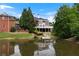 Beautiful water view of the home and its expansive backyard, featuring lush greenery and tranquil lake reflections at 5070 Riverlake Dr, Peachtree Corners, GA 30097