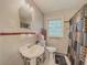 Well-lit bathroom featuring a pedestal sink, standard toilet, and shower-tub combo at 646 Quillian Ave, Decatur, GA 30032