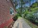 View of the side yard featuring a brick home with an adjacent driveway and some shrubbery at 646 Quillian Ave, Decatur, GA 30032