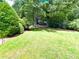Spacious backyard with lush green grass and mature trees providing ample shade, great for outdoor enjoyment at 3419 White Sands Way, Suwanee, GA 30214