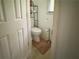 A clean, modest bathroom space featuring a toilet, toilet paper holder, and a small area rug for added comfort at 3419 White Sands Way, Suwanee, GA 30214