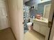 Bathroom featuring patterned wallpaper, shower with curtain, toilet, and vanity with storage at 3419 White Sands Way, Suwanee, GA 30214