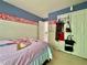 Bedroom with a unicorn themed bedspread, and a closet with clothes hanging on the rod at 3419 White Sands Way, Suwanee, GA 30214