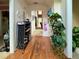 Hallway with hardwood floors, leading to different rooms, decorated with plants and wall art at 3419 White Sands Way, Suwanee, GA 30214