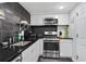 Modern kitchen featuring stainless steel appliances, dark countertops, and black backsplash at 1501 Clairmont Rd # 1522, Decatur, GA 30033