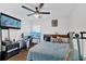 Bright bedroom with a TV, ceiling fan, bed, and desk with multiple monitors at 2210 Polar Rock Sw Ave, Atlanta, GA 30315