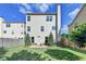 View of the back of the home featuring a large yard with landscaping and a privacy fence at 3128 Onamia Rd, Duluth, GA 30096