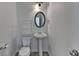 Bathroom with a pedestal sink, modern lighting, and a sleek oval mirror at 3128 Onamia Rd, Duluth, GA 30096
