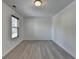 An empty bedroom featuring hardwood floors and a bright white paint, with a window at 3128 Onamia Rd, Duluth, GA 30096