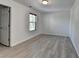 An empty bedroom featuring hardwood floors and a bright white paint, with a window and a door at 3128 Onamia Rd, Duluth, GA 30096