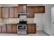The kitchen features wood cabinets, stainless steel appliances, granite countertops, and tile backsplash at 3128 Onamia Rd, Duluth, GA 30096
