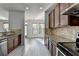Kitchen boasts wood cabinets, stainless appliances, granite counters, open to dining area with backyard views at 3128 Onamia Rd, Duluth, GA 30096