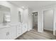 Elegant bathroom with double sinks, white cabinets, and wood-look flooring, offering both style and functionality at 6905 Winchester Pl, Fairburn, GA 30213