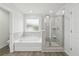 Well-lit bathroom featuring a tiled shower with glass door and a separate soaking tub for relaxation at 6905 Winchester Pl, Fairburn, GA 30213