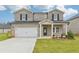 Charming two-story home features a brick facade, a two-car garage and a well manicured front yard at 6905 Winchester Pl, Fairburn, GA 30213
