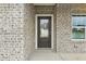 A welcoming front entrance featuring a black front door, brick facade, and a charming window at 6905 Winchester Pl, Fairburn, GA 30213