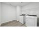 Functional laundry room with modern washer and dryer and overhead wire shelf at 6905 Winchester Pl, Fairburn, GA 30213