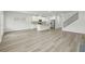 Large, open living area featuring hardwood floors, white walls, and a modern kitchen at 6905 Winchester Pl, Fairburn, GA 30213