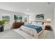 This staged primary suite is complete with a king bed, two windows, two nightstands, and neutral décor at 6905 Winchester Pl, Fairburn, GA 30213