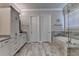 Bright bathroom featuring a bathtub and vanity with cabinets for storage at 919 Olmsted Ln, Johns Creek, GA 30097
