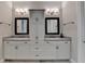Bathroom boasting dual sinks, vanity with storage cabinets, framed mirrors and modern lighting at 919 Olmsted Ln, Johns Creek, GA 30097