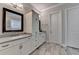 Bright bathroom with double vanities, gray countertop, white cabinets, and tiled floor at 919 Olmsted Ln, Johns Creek, GA 30097