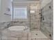 Bathroom featuring a bathtub, shower, and a window that allows in natural light at 919 Olmsted Ln, Johns Creek, GA 30097