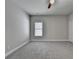 Bright, carpeted bedroom with a ceiling fan and a large window bringing in natural light at 919 Olmsted Ln, Johns Creek, GA 30097