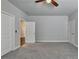 Carpeted bedroom featuring a ceiling fan, closet, and doorway to the rest of the house at 919 Olmsted Ln, Johns Creek, GA 30097