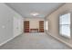 Spacious bonus room with neutral walls, plush carpeting, and bookshelves offers flexible space at 919 Olmsted Ln, Johns Creek, GA 30097