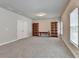 Spacious bonus room with neutral walls, plush carpeting, and bookshelves offers flexible space at 919 Olmsted Ln, Johns Creek, GA 30097