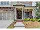 Close up of the home's entry, with brick facade, covered porch, and manicured landscaping at 919 Olmsted Ln, Johns Creek, GA 30097