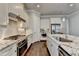 Modern kitchen featuring an island, stainless steel appliances, granite countertops, white cabinets and hardwood floors at 919 Olmsted Ln, Johns Creek, GA 30097