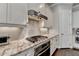 Modern kitchen featuring granite countertops, stainless steel appliances, white cabinets and hardwood floors at 919 Olmsted Ln, Johns Creek, GA 30097